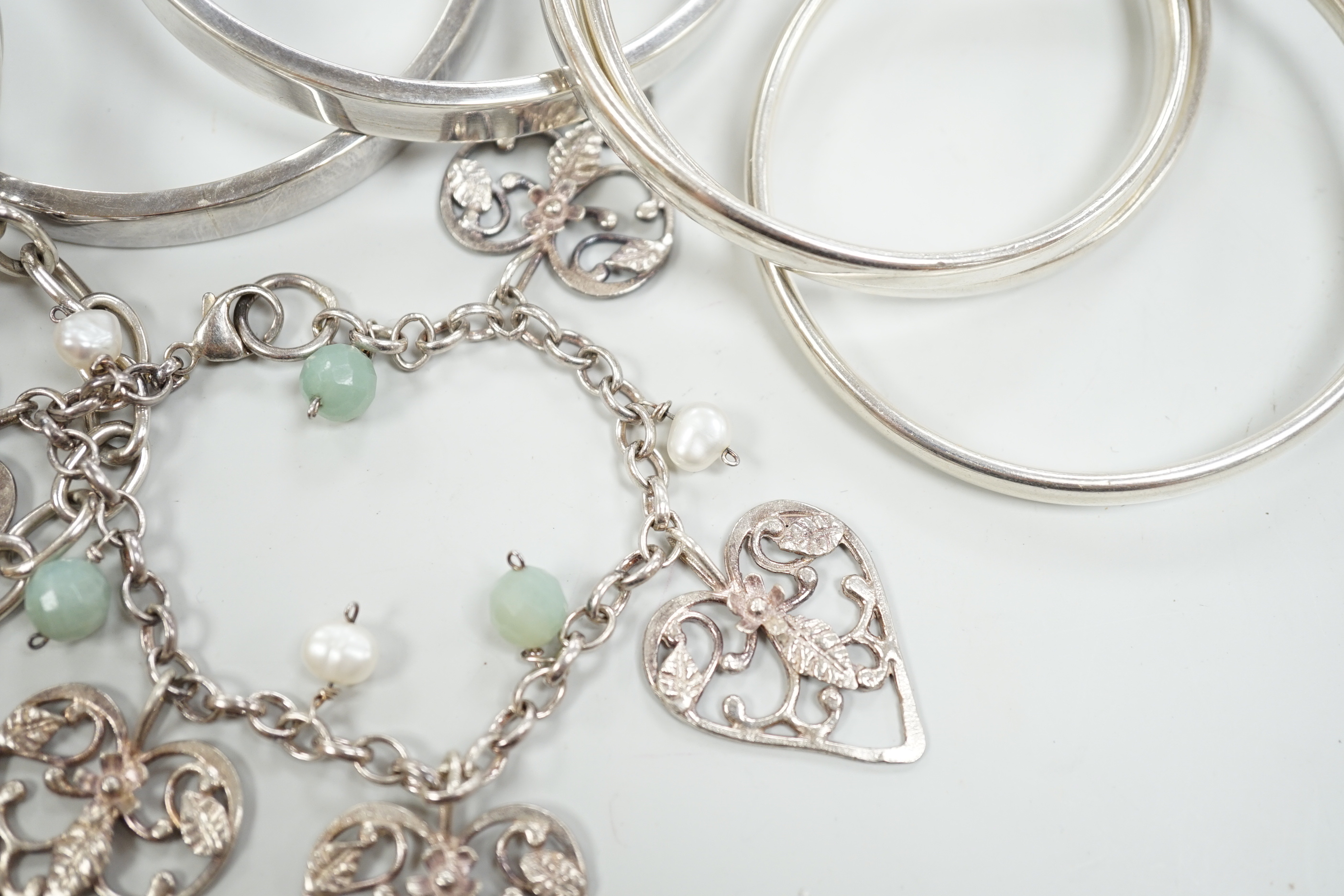 Three Pruden Smith bangles including triple loop, two other silver bangles, a white metal heart bracelet and one other bracelet, together with a straight edge rule by Mary Ann Simmons.